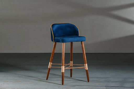A blue dining room chair in a studio with gray walls