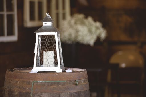 A closeup shot of a candle lantern on a wooden barrel with a blurred background