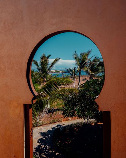 A vertical shot of a beach shore seen through a window on a sunny day