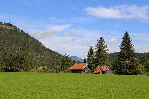 A beautiful shot of mountain huts on green meadows in the Alps