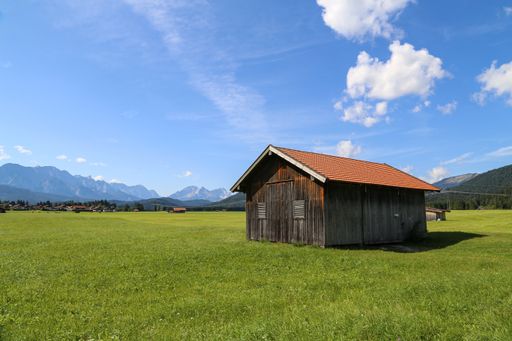 A beautiful shot of huts on green meadows in the Alps