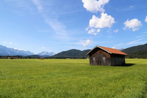 A closeup shot of mountain huts on green meadows in the Alps