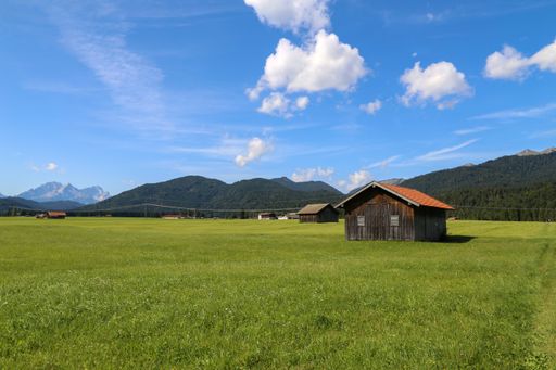 Mountain huts on green meadows in summer in the Alps