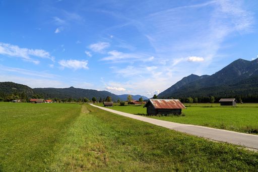 A mesmerizing shot of mountain huts on green meadows in summer in the Alps