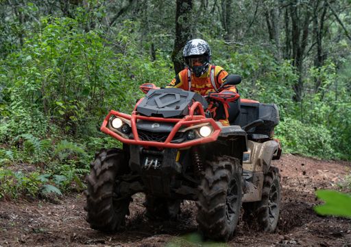 A rider taking ATV through terrain uphill