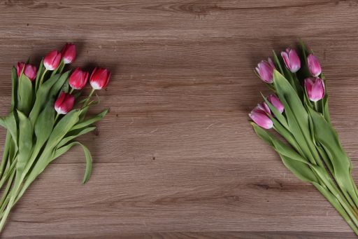 A top view of beautiful colorful tulips on the wooden table