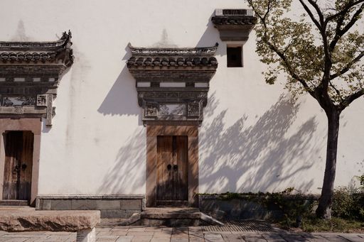 Traditional classic Chinese wooden doors and white exterior wall of an ancient Chinese house