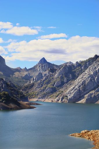 A vertical shot of the Elsa river and majestic mountains in the background in Riano reservoir Castilla Leon