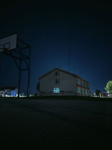 A vertical shot of a school building under the beautiful starry night sky