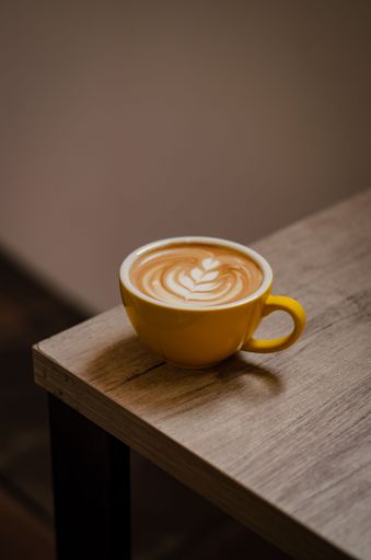 A vertical close-up shot of a cappuccino in a cup