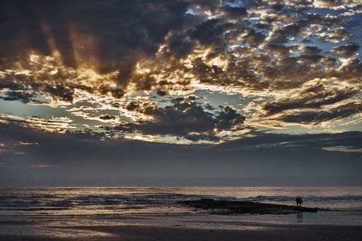 A breathtaking shot of the reflection of the cloudy sky in the ocean during sunset