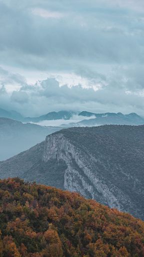 A scenic shot of the green valleys under the blue cloudy sky
