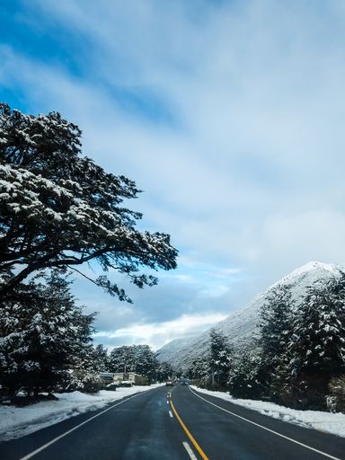 A vertical shot of a highway road in the snowy mountains in New Zealands Southern Alps