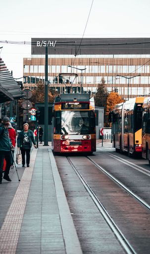 A tram in Lodz, near the Fabryczna Train Station with walking people