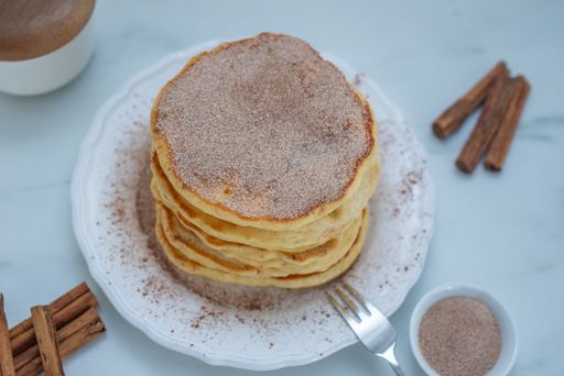 A stack of freshly made pancakes on a white plate