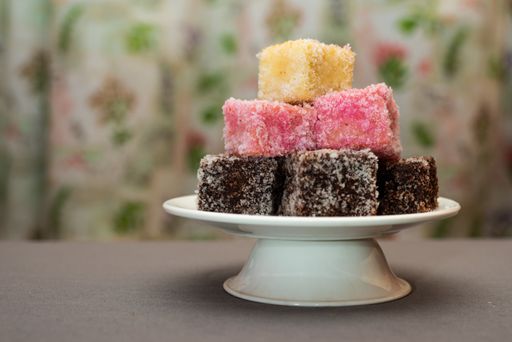 A closeup shot of colourful Australian dessert Lamingtons stacked and served on a cake stand