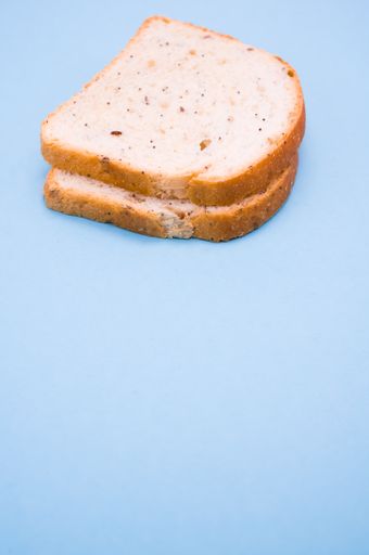 A vertical shot of two slices of bread isolated on turquoise background