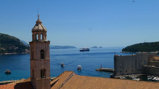 A landscape shot of a tower in Dubrovnik, Croatia, in the background of Adriatic sea with cruise ships