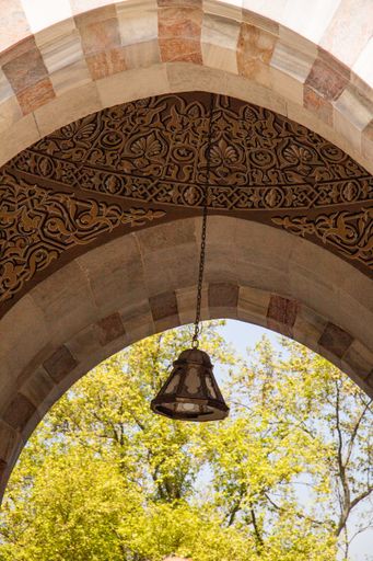 A vertical shot of a decorative ceiling with an old lamp hanging on it