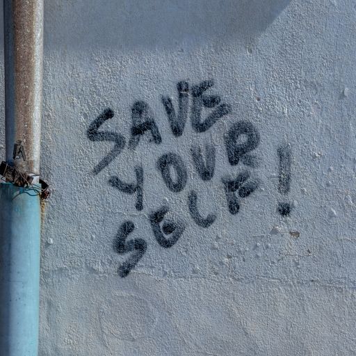 A closeup shot of a wall with a save yourself lettering on it as background