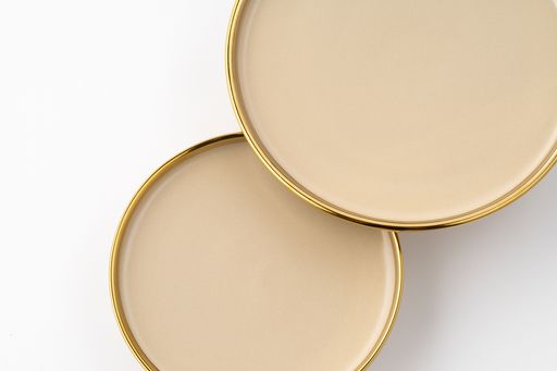 A set of light brown ceramic plate on a white background. Top view