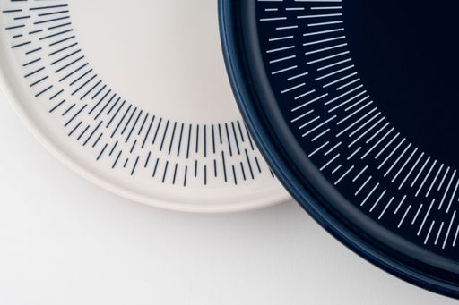 A closeup shot of a blue and white mug on a saucer with a white background