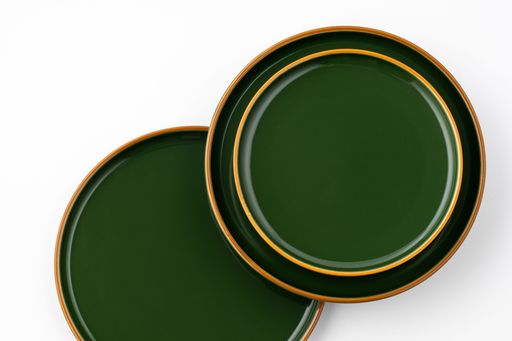 A set of green ceramic plates on a white background. Top view