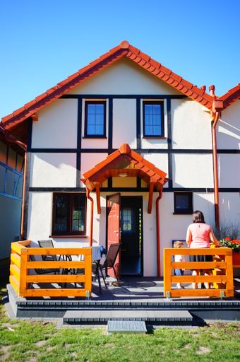 Front entrance of a vacation house with woman standing by the open door.