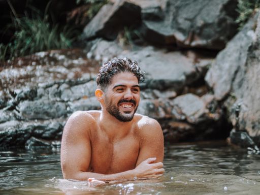 A shirtless male Caucasian enjoying a day at a river