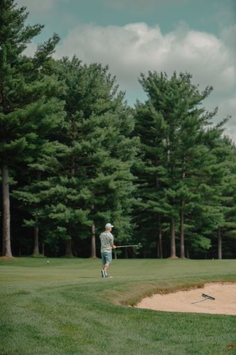A vertical shot of a man playing on a golf course in the Grand Rapids, Michigan