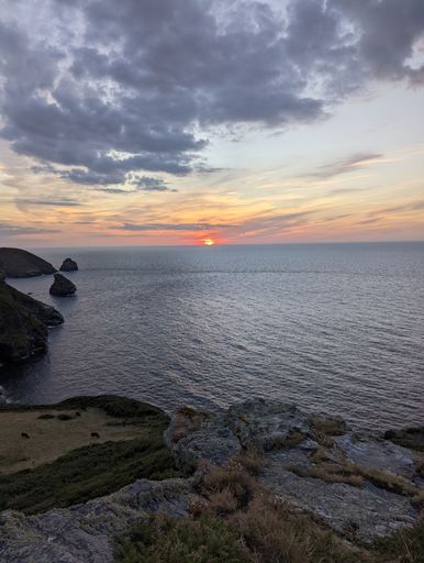 A beautiful shot of a sunset with a cloudy sky over a calm sea