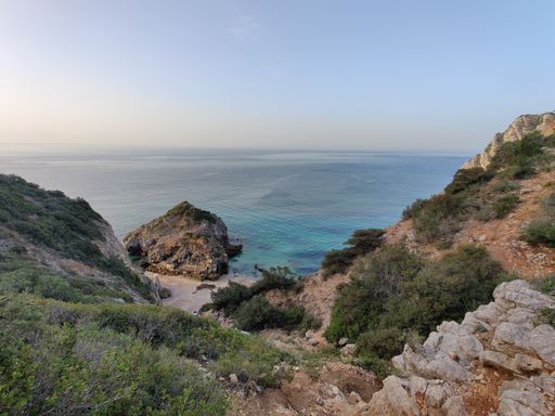 A scenic shot of a rocky beach on the coast of Sesimbra in Portugal