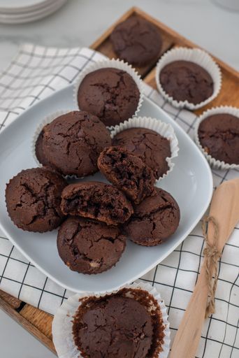 A vertical shot of chocolate muffins on wooden board
