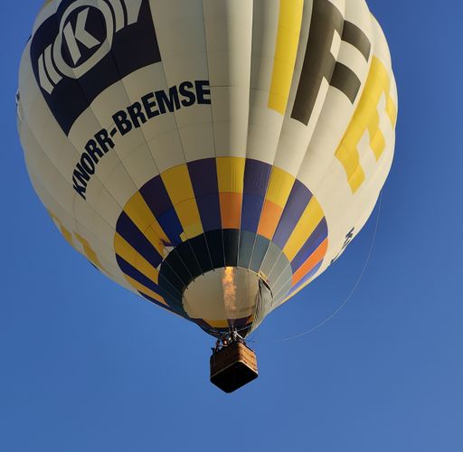 A low angle shot of the Knorr-Bremse hot air balloon with flame