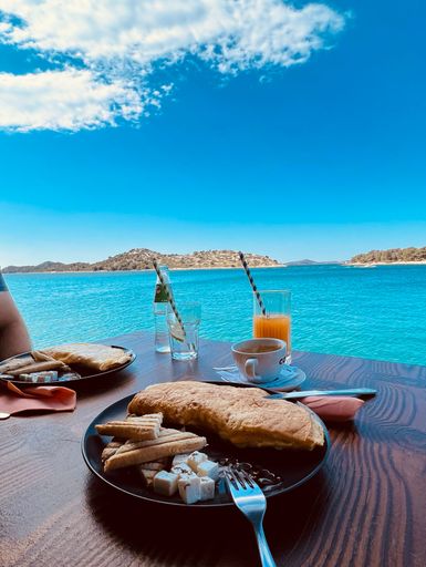 A vertical of a breakfast for two served by a beach