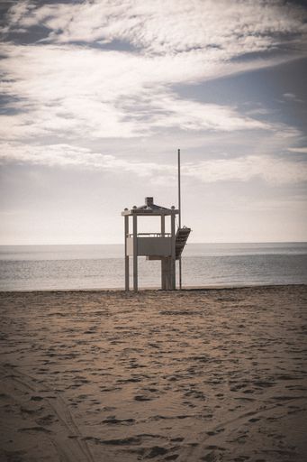 A vertical shot of a lifeguard tower on the seaside during the daytime - suitable for a wallpaper