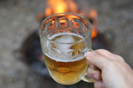 A closeup shot of a person holding a glass of cold beer