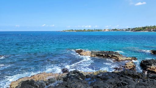 A scenic shot of a rocky beach under a clear blue sky