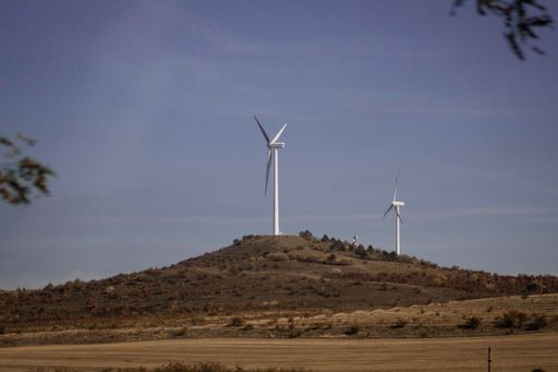 A landscape view with windmills on a yellow hill, clear sky in the background