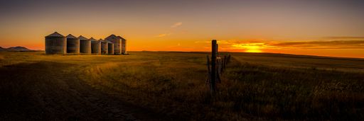 A panoramic shot of grain silos in Montana during the sunset