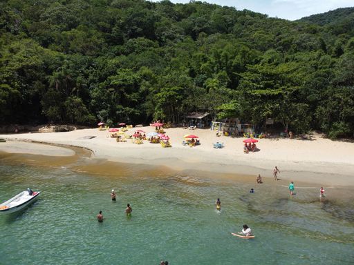 An aerial shot of the Da Barra Do Sahy sandy beach with vacationers near the clear sea