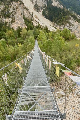 A beautiful suspension bridge leading to the trees and mountains in canton Valais