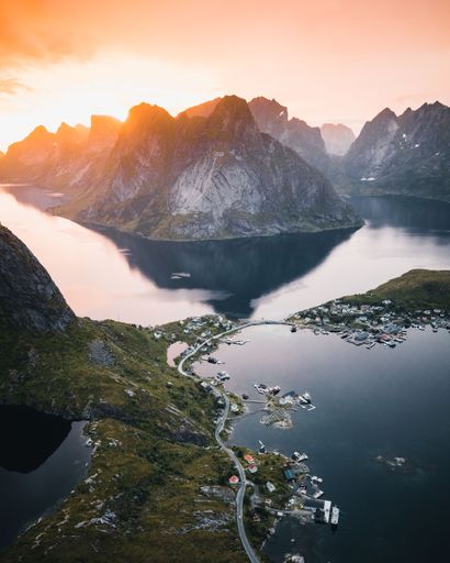 A vertical shot of a lake surrounded by rocky hills during the sunset in Austria