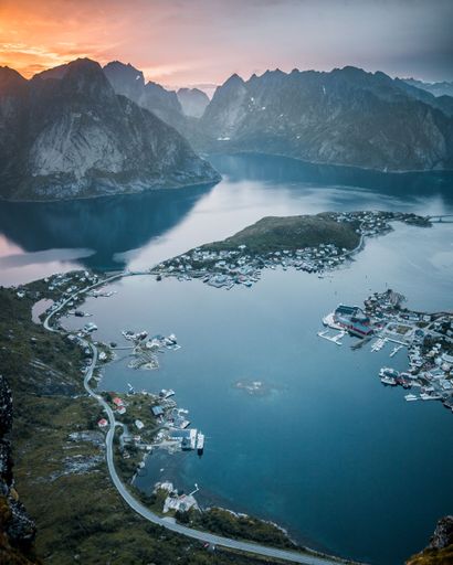A vertical shot of a lake surrounded by rocky hills during the sunset in Austria
