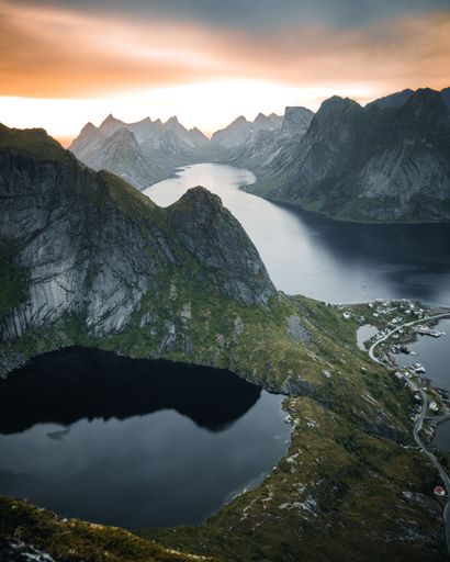 A vertical shot of a lake surrounded by rocky hills during the sunset in Austria
