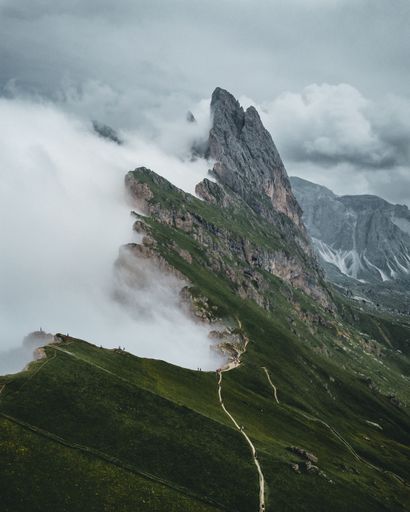 A vertical shot of the Seceda mountain covered in the fog in winter in Italy