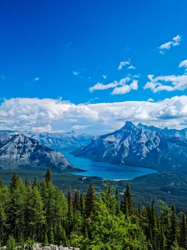A vertical aerial view of snowy mountains and a lake in Banff National Park in Alberta