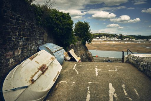 An old rusty boat abandoned by rocky hill in near the shore