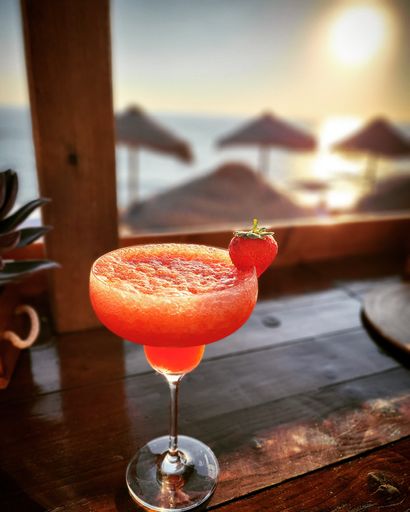 A vertical shot of a strawberry drink at sunset on an isolated background