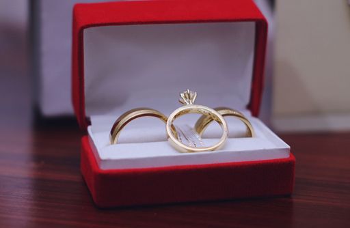 A closeup shot of gold marriage rings in a red box